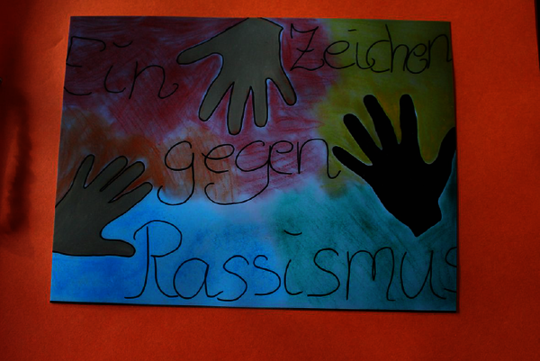 Ein gemaltes Bild mit drei Händen und der Aufschrift "Ein Zeichen gegen Rassismus".